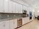 Contemporary kitchen showcasing white cabinets, stainless steel appliances, and backsplash, complementing hardwood floors at 15625 Hawks Crest Loop, Odessa, FL 33556