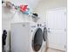 Well-equipped laundry room with modern washer and dryer, shelving for storage, and convenient access to the door at 15625 Hawks Crest Loop, Odessa, FL 33556