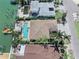 The aerial view showcases the expansive layout, lush landscaping, sparkling pool, and waterfront location at 16353 Redington Dr, Redington Beach, FL 33708