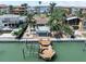 Backyard aerial view showing waterfront property, a boat dock, pool, and covered cabana with seating at 16353 Redington Dr, Redington Beach, FL 33708