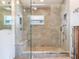 Modern glass shower featuring stone flooring, built in bench and double shower heads at 16353 Redington Dr, Redington Beach, FL 33708