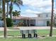 Charming home featuring a front bench, driveway, and a well maintained lawn at 16353 Redington Dr, Redington Beach, FL 33708