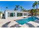 View of the pool with updated exterior and large glass doors and windows at 16353 Redington Dr, Redington Beach, FL 33708