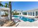 Beautiful backyard pool area featuring waterfront access, a gazebo with swing, and mature palm trees at 16353 Redington Dr, Redington Beach, FL 33708