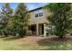 Charming backyard featuring lush trees and a covered patio for outdoor relaxation and entertaining at 1969 Milkweed Trce, Lutz, FL 33558