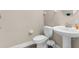 Clean and simple half bathroom featuring a pedestal sink and standard toilet at 1969 Milkweed Trce, Lutz, FL 33558
