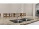 Granite island with stainless steel sink and faucet, perfect for food preparation and casual dining at 1969 Milkweed Trce, Lutz, FL 33558