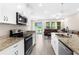 Beautiful kitchen featuring stainless steel appliances, granite countertops, and an adjacent living area with pond views at 1969 Milkweed Trce, Lutz, FL 33558