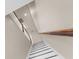 Staircase with black and white steps, wooden railing, and bright natural light, offering a clean and modern design at 1969 Milkweed Trce, Lutz, FL 33558