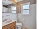 This bathroom features a toilet, wooden vanity, medicine cabinet, and tiled walls at 1984 Trotter Rd, Largo, FL 33774