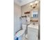 This bathroom features a toilet, sink, shelves, and a mirror at 1984 Trotter Rd, Largo, FL 33774
