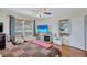 This bedroom features hardwood floors, a ceiling fan, and two windows allowing for natural light at 1984 Trotter Rd, Largo, FL 33774