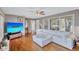 Bright living room featuring hardwood floors, a white sectional sofa, and ample natural light at 1984 Trotter Rd, Largo, FL 33774