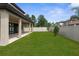 A spacious backyard enclosed with a white fence, complemented by lush green grass and manicured landscaping at 21878 Amelia Rose Way, Land O Lakes, FL 34637