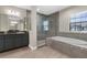 Bathroom with double vanity, walk-in shower, soaking tub, and tile accents, creating a luxurious retreat at 21878 Amelia Rose Way, Land O Lakes, FL 34637