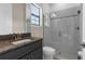 Bathroom with a granite-topped vanity, frameless glass shower, and neutral tile at 21878 Amelia Rose Way, Land O Lakes, FL 34637