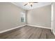A well-lit, neutral bedroom with wood-look flooring, ceiling fan, and a window with blinds at 21878 Amelia Rose Way, Land O Lakes, FL 34637