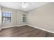 Comfortable bedroom with hardwood floors, natural light from windows and a ceiling fan at 21878 Amelia Rose Way, Land O Lakes, FL 34637