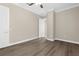 Bright bedroom featuring wood-look floors, a ceiling fan, and a neutral color scheme at 21878 Amelia Rose Way, Land O Lakes, FL 34637