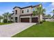 Beautiful exterior elevation with a three-car garage, paver driveway, and well maintained lawn and landscaping at 21878 Amelia Rose Way, Land O Lakes, FL 34637