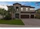 Elegant two-story home featuring stone accents, a three-car garage, a tile roof and a well manicured lawn at 21878 Amelia Rose Way, Land O Lakes, FL 34637