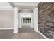 Inviting hallway featuring stone accent wall, gray carpet and view of the backyard at 21878 Amelia Rose Way, Land O Lakes, FL 34637