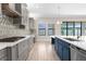 A modern kitchen featuring gray cabinets, white countertops, stainless steel appliances and stylish backsplash at 21878 Amelia Rose Way, Land O Lakes, FL 34637