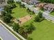 Aerial view of a playground surrounded by green grass, mature trees and neighborhood at 21878 Amelia Rose Way, Land O Lakes, FL 34637