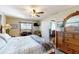 Bright bedroom features a ceiling fan, wood flooring, and dresser at 22396 Nyack Ave, Port Charlotte, FL 33952