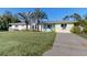 Charming one-story home featuring well-maintained lawn, palm trees, and a welcoming driveway at 22396 Nyack Ave, Port Charlotte, FL 33952