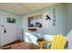 Inviting entrance with cheerful blue siding, white trim, and a cozy yellow chair at 22396 Nyack Ave, Port Charlotte, FL 33952