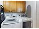 The laundry room features a side-by-side washer and dryer, cabinets, and ironing board at 22396 Nyack Ave, Port Charlotte, FL 33952