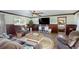 Spacious living room featuring wood-look flooring, ceiling fan, and cozy furniture at 22396 Nyack Ave, Port Charlotte, FL 33952