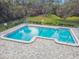 Up-close aerial view of rectangular pool and deck area featuring chairs, tables, and more at 232 Hunter Ct, Palm Harbor, FL 34684