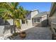 Charming home exterior with brick paved courtyard, complemented by a lush palm tree and tasteful landscaping at 232 Hunter Ct, Palm Harbor, FL 34684