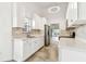 Bright white kitchen offers stainless steel appliances, tiled floor and stone counters with open access to the dining room at 232 Hunter Ct, Palm Harbor, FL 34684