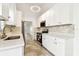 Bright white kitchen with stainless steel appliances, tiled floor and stone counters and mosaic backsplash at 232 Hunter Ct, Palm Harbor, FL 34684