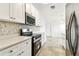 Modern kitchen features white cabinets, stainless steel appliances, and stylish backsplash at 232 Hunter Ct, Palm Harbor, FL 34684
