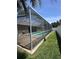 An enclosed pool and view of the backyard with green grass and a white fence at 2603 Valencia Grove Dr, Valrico, FL 33596