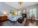 Cozy bedroom with a decorative fireplace, wood floors, and a comfortable queen bed at 2674 Tanglewood Trl, Palm Harbor, FL 34685