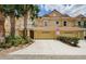 Inviting townhome with a two-car garage, tropical landscaping, and an attractive tile roof at 2674 Tanglewood Trl, Palm Harbor, FL 34685