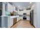 Modern kitchen features white cabinetry, stainless steel appliances and neutral ceramic tile floors at 2674 Tanglewood Trl, Palm Harbor, FL 34685