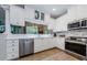 A well-lit kitchen with white cabinets, stainless steel appliances, and quartz countertops with open layout at 2674 Tanglewood Trl, Palm Harbor, FL 34685