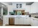 A modern kitchen with white cabinets, stainless steel appliances, and quartz countertops at 2674 Tanglewood Trl, Palm Harbor, FL 34685