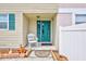 Inviting front entrance featuring a decorative teal door and a cozy rocking chair at 2811 S Pines Dr # 15, Largo, FL 33771