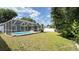 Spacious backyard featuring a screened-in pool and lush landscaping at 28818 Midnight Star Loop, Wesley Chapel, FL 33543