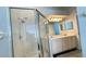 Shower in bright bathroom with dual sinks and vanity with modern lighting at 28818 Midnight Star Loop, Wesley Chapel, FL 33543