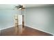 Bedroom features hardwood floors, ceiling fan, and open doorway to the bathroom at 28818 Midnight Star Loop, Wesley Chapel, FL 33543