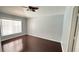 Spacious bedroom with hardwood floors, large window, and ceiling fan at 28818 Midnight Star Loop, Wesley Chapel, FL 33543