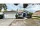 Charming one-story home with blue exterior, attached garage, and well-kept front yard at 28818 Midnight Star Loop, Wesley Chapel, FL 33543